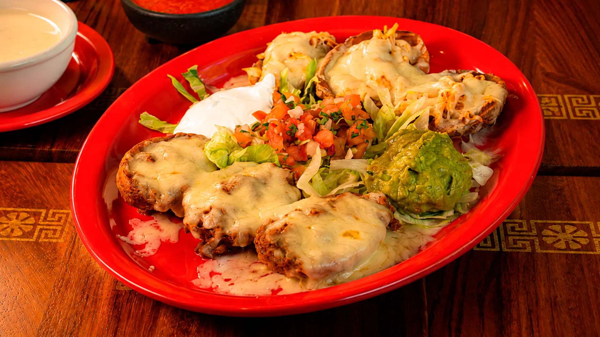 Sopes topped with cheese, pico de gallo and guacamole